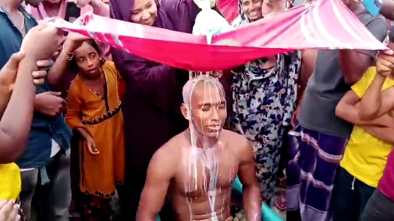 মাথা ন্যাড়া করে দুধ দিয়ে গোসল করছেন আহাদ আলী। ছবি : সংগৃহীত