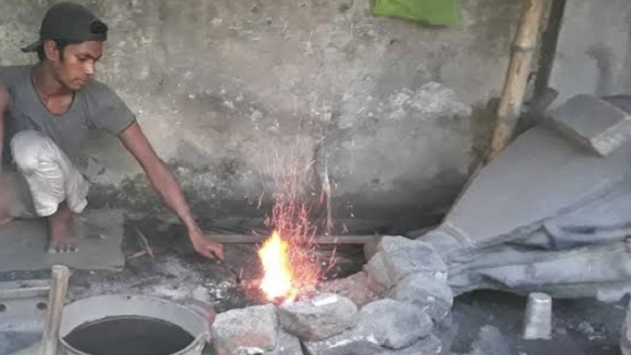 আগুনে লোহা গলাচ্ছেন এক কামার শিল্পী। ছবি : কালবেলা