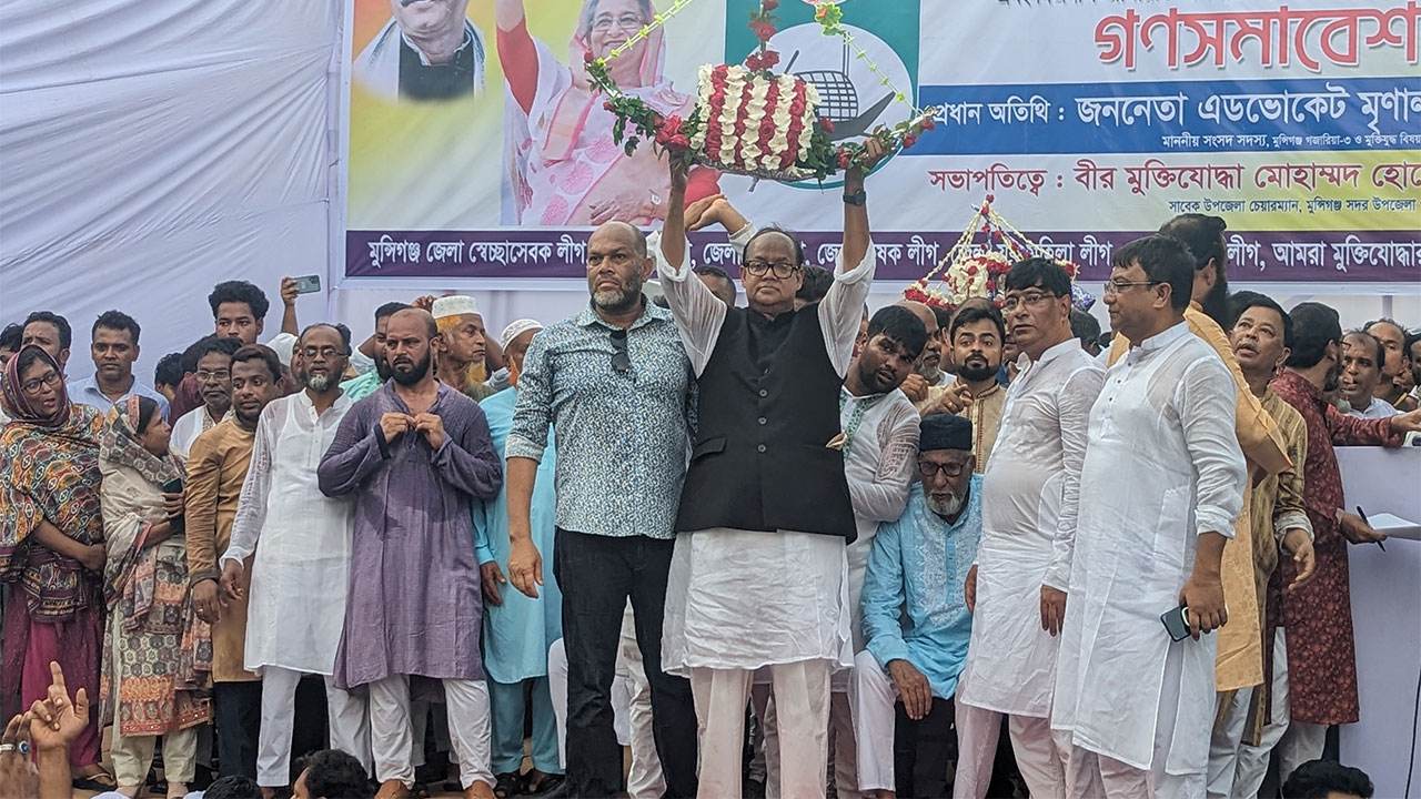 নৌকা উচু করে দাঁড়িয়ে আছেন মুন্সীগঞ্জ-৩ আসনের সংসদ সদস্য অ্যাডভোকেট মৃণাল কান্তি দাস। ছবি: কালবেলা