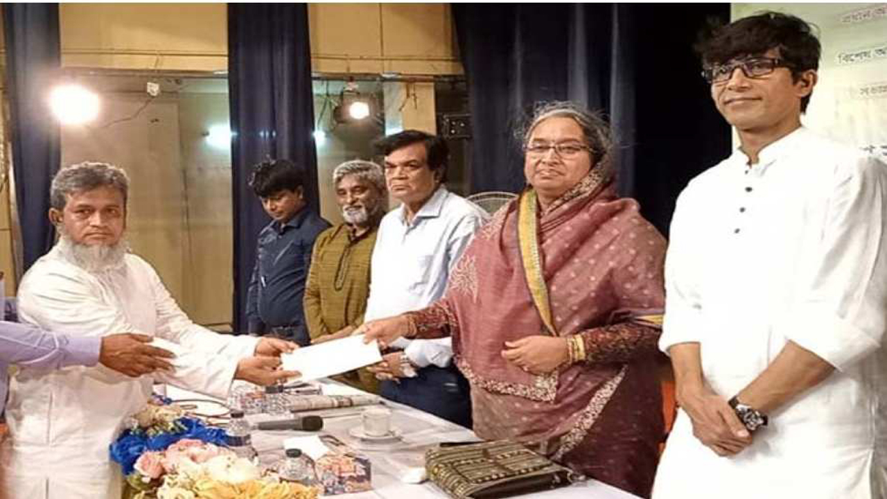 সাংবাদিকের মাঝে অনুদানের চেক হস্তান্তর করছেন শিক্ষামন্ত্রী। ছবি: কালবেলা