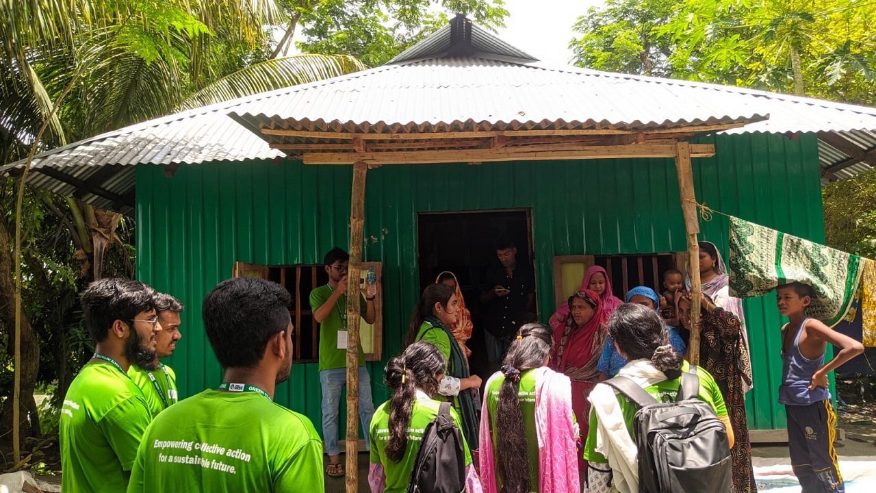 একটি বাড়িতে গিয়ে বাসিন্দাদের সতর্ক করছেন গ্রিন ক্লাইমেট ইনিশিয়েটিভ এর সদস্যরা। ছবি : কালবেলা