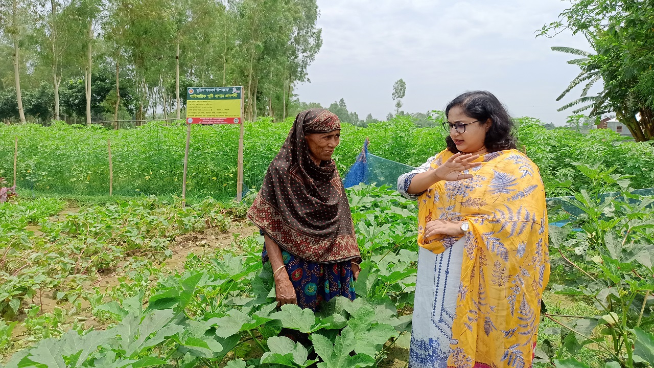 উল্লাপাড়ায় পুষ্টি বাগানে কৃষাণীকে পরামর্শ দিচ্ছেন কৃষি কর্মকর্তা সুবর্ণা ইয়াসমিন। ছবি : কালবেলা