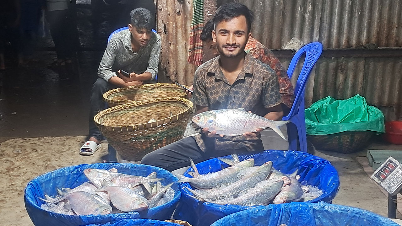 মৎস্য আড়তে ইলিশ হাতে বিক্রেতা। ছবি : কালবেলা