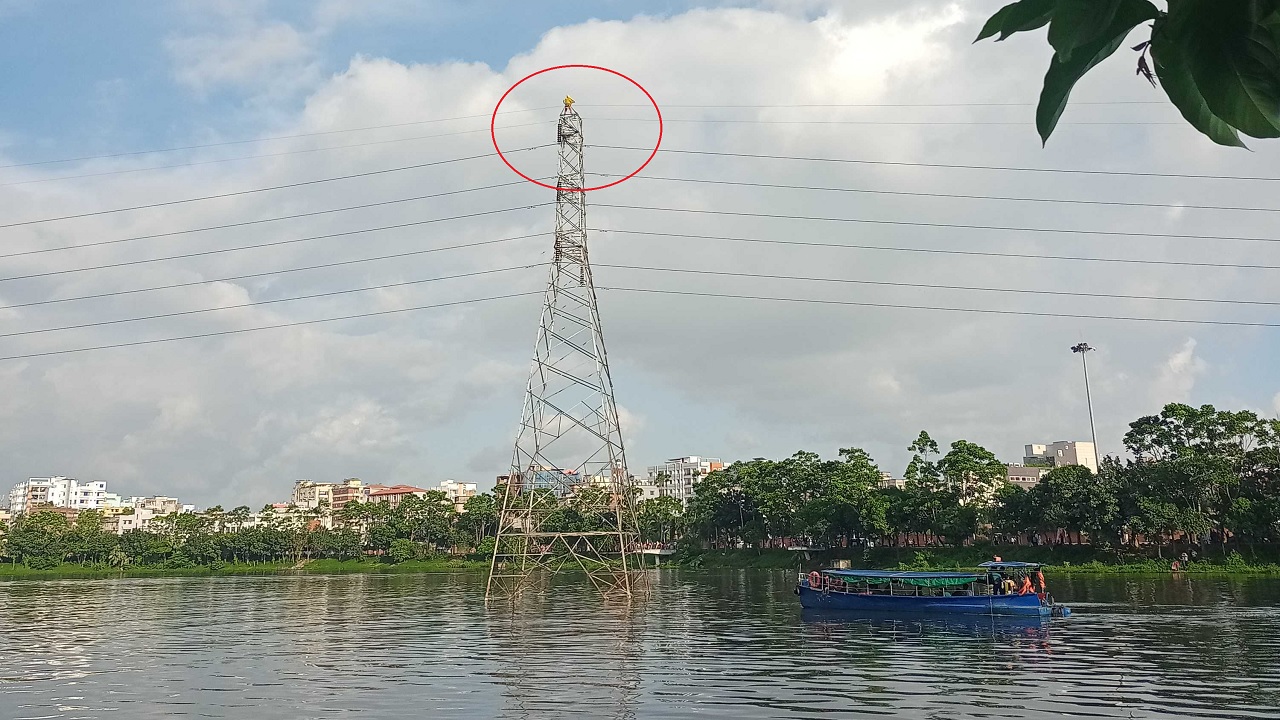 হাতিরঝিলে ১১শ কেভির বৈদ্যুতিক টাওয়ারের চূড়ায় বসে আছেন নারী। ছবি : সংগৃহীত