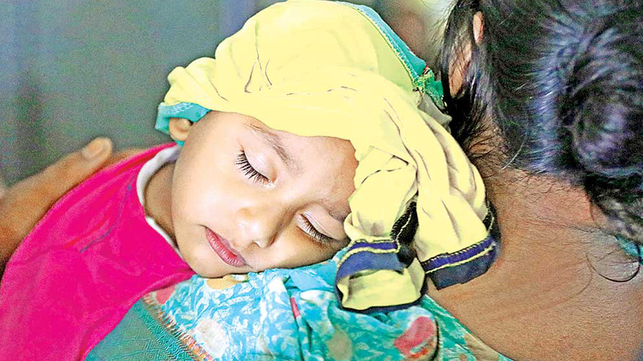 রাজধানীর মুগদা হাসপাতালে মায়ের কোলে ডেঙ্গু আক্রান্ত এক শিশু। ছবি : কালবেলা