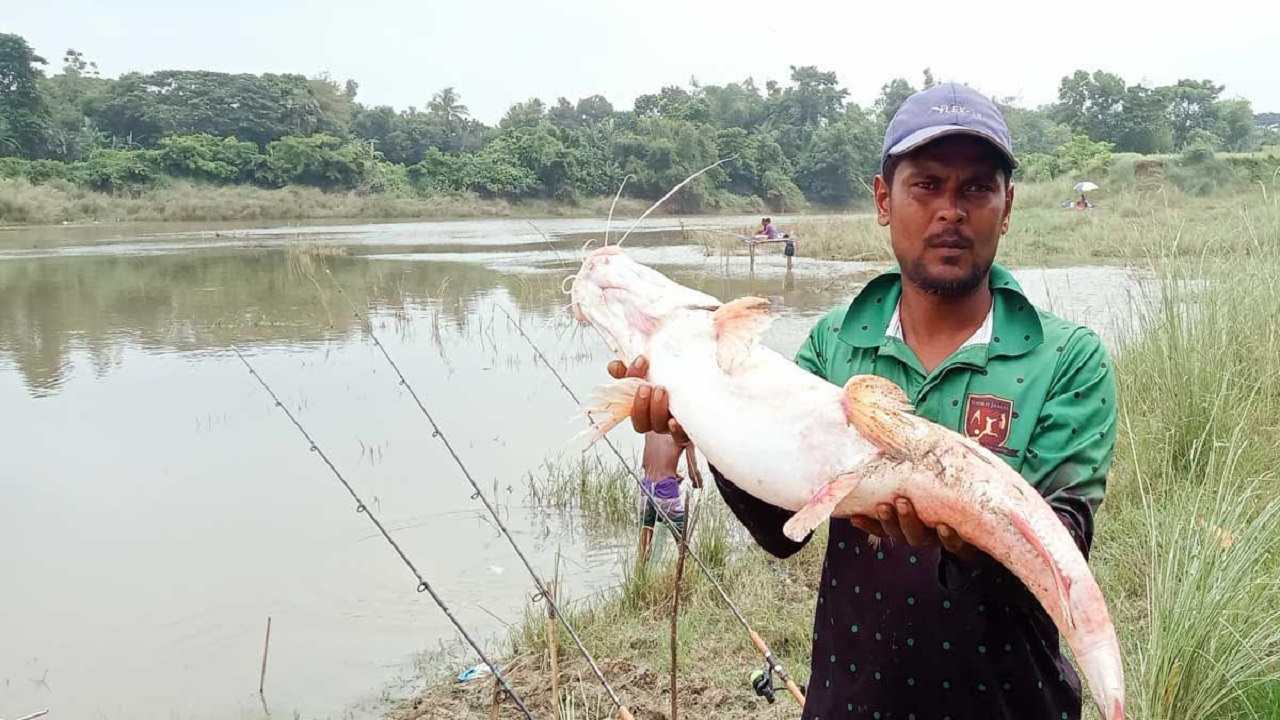 বড়শিতে ধরা পড়া মাছ হাতে আলী হোসেন। ছবি : কালবেলা