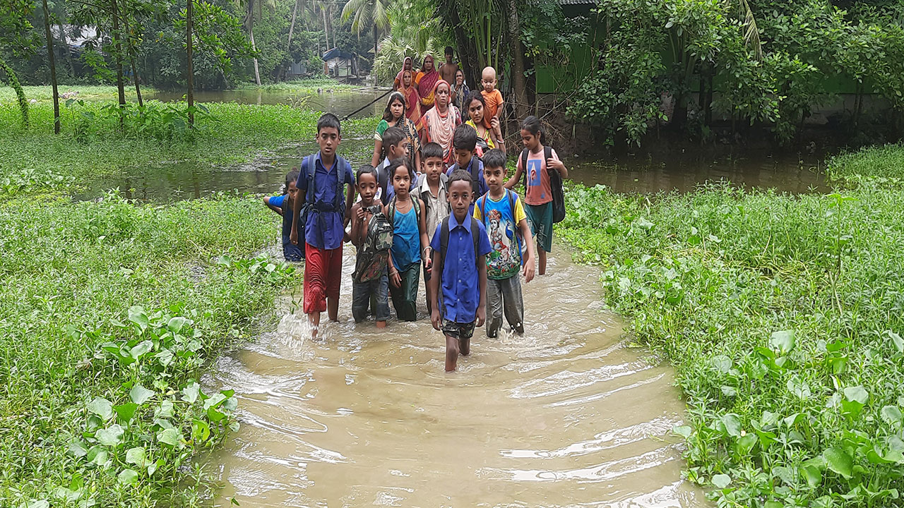 হাঁটু পানি সমান রাস্তা পার হয়ে স্কুলে যাচ্ছে শিশুরা। ছবি : কালবেলা