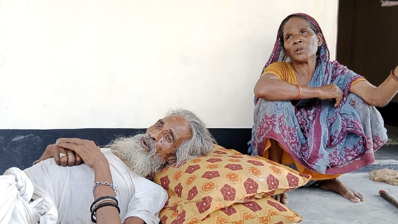 আশ্রয়ণ প্রকল্পের ঘরের বারান্দায় বিষণ্ণ গোলজার-রোকেয়া দম্পতি। ছবি : কালবেলা