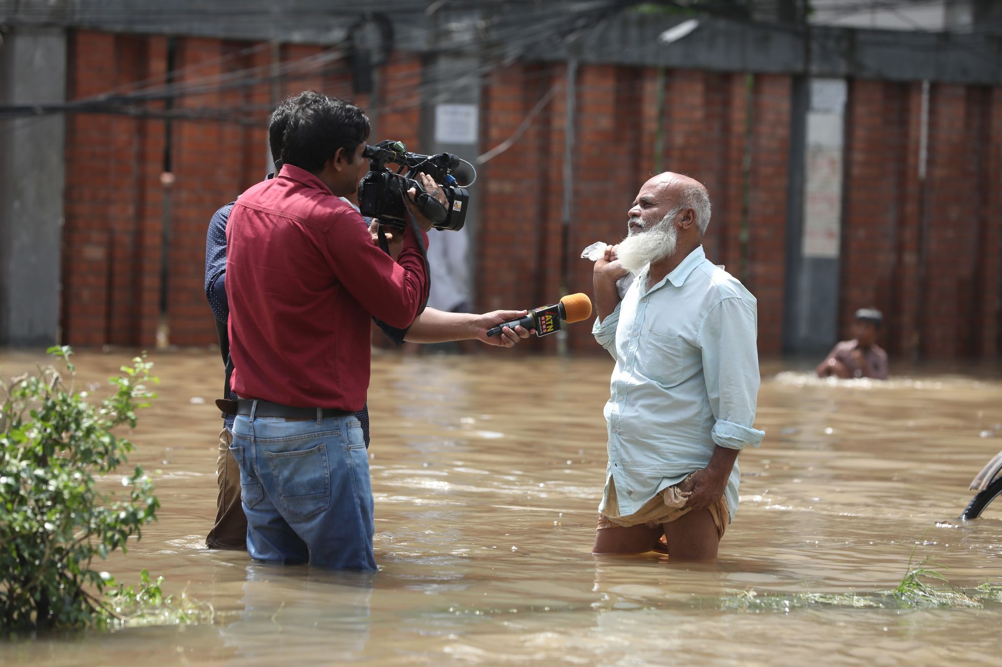 জলাবদ্ধতায় দুর্ভোগে পড়া সাধারণ মানুষের খবর নিচ্ছেন গণমাধ্যমকর্মী।