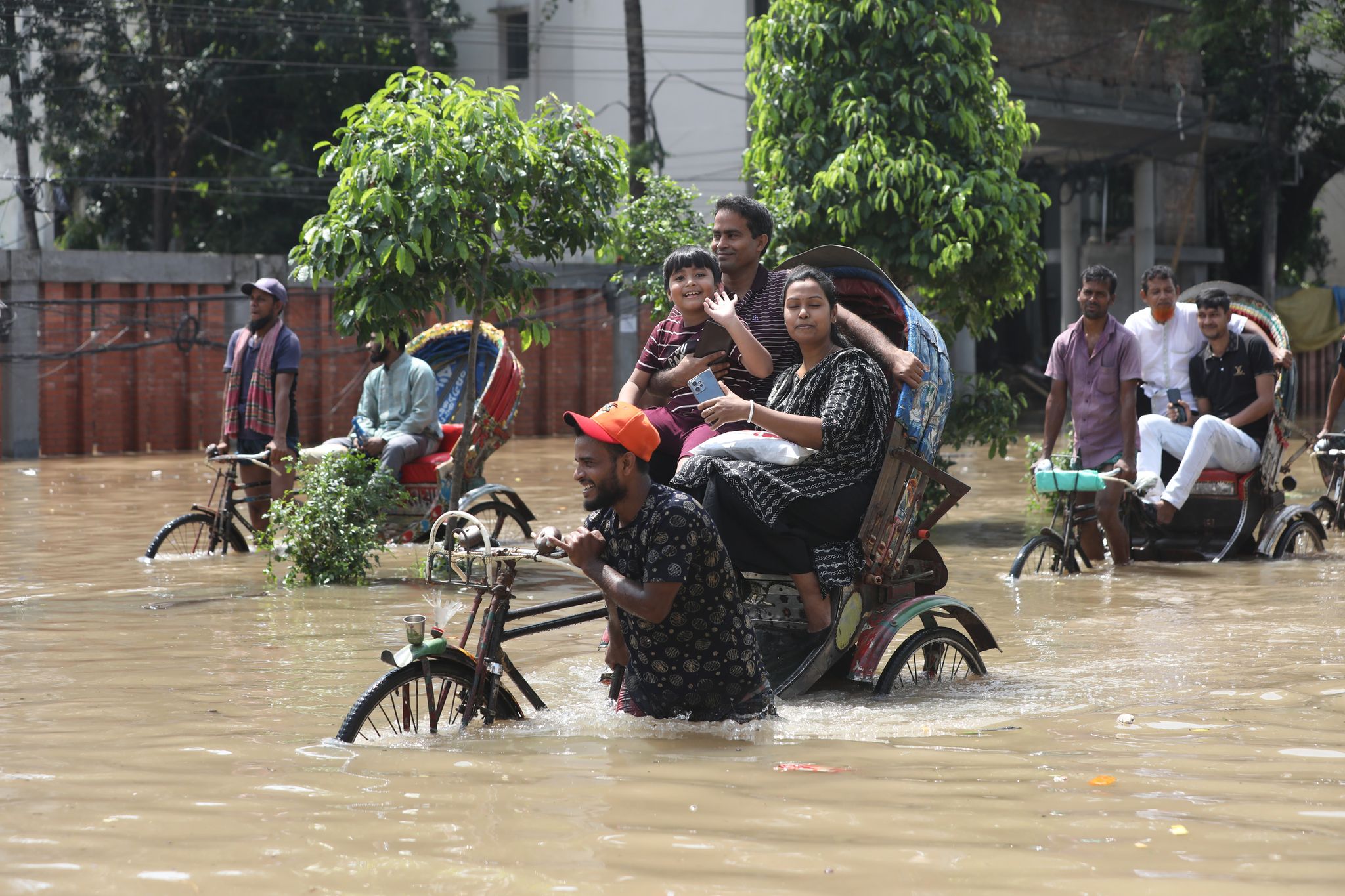 জলাবদ্ধ রাস্তায় ক্যামেরা দেখেই উচ্ছ্বাস প্রকাশ করছে রিকশাযাত্রী এ শিশু।