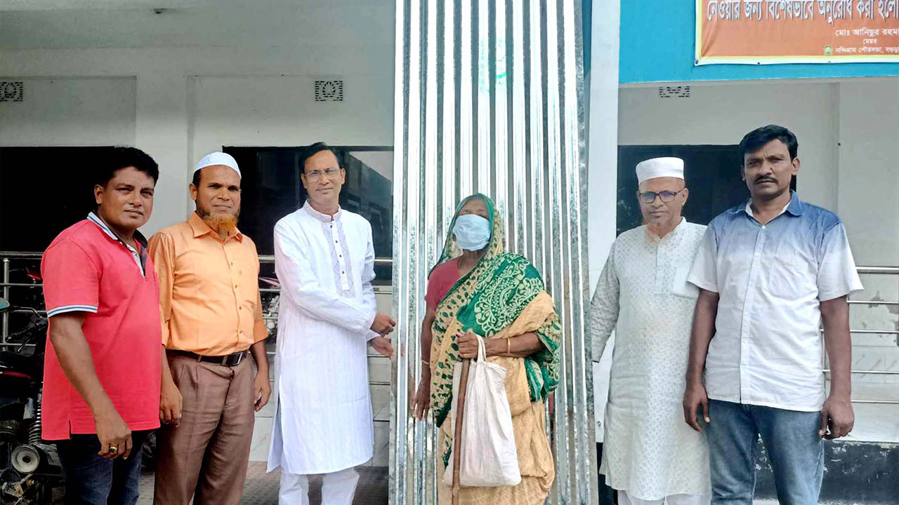 অসহায় মালেকা বেগমকে ঢেউটিন দিচ্ছেন পৌরসভার মেয়র মো. আনিছুর রহমান। ছবি : কালবেলা