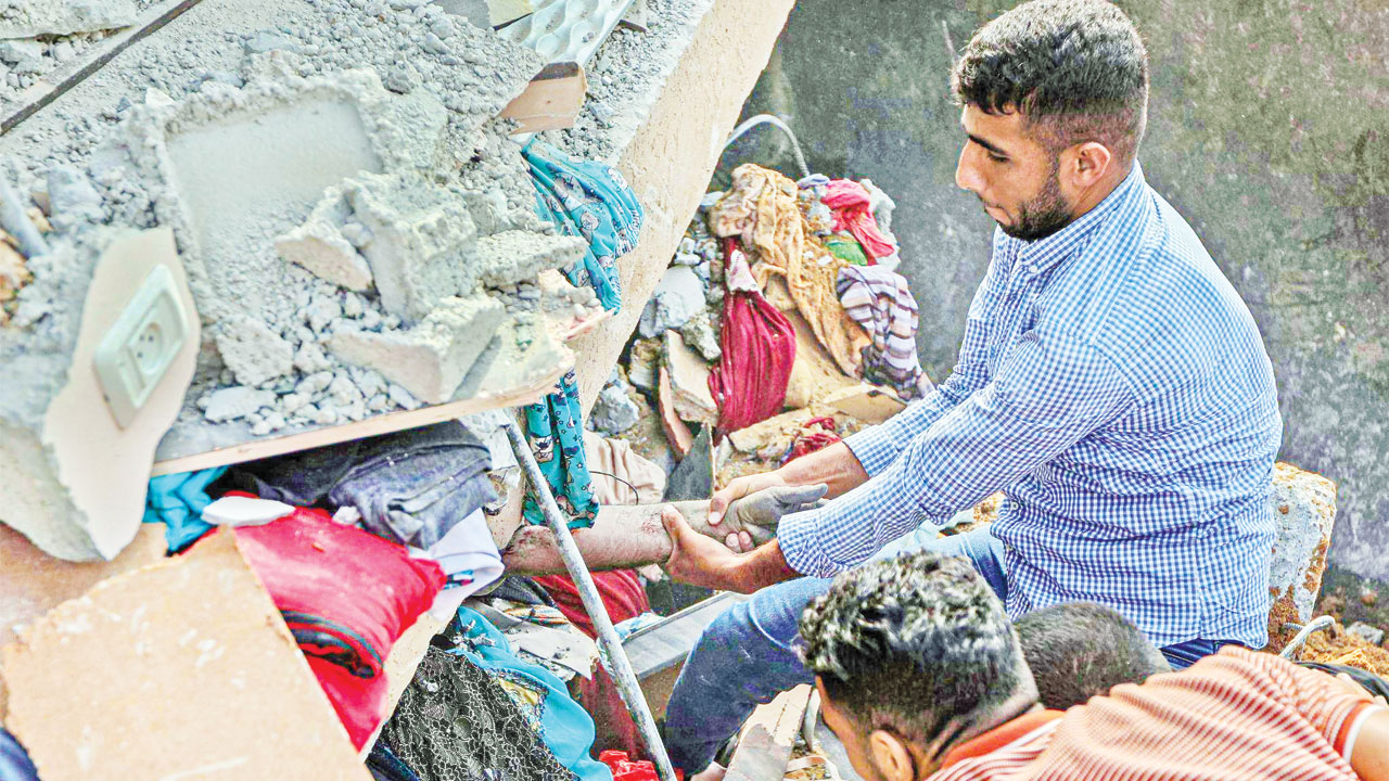 হামলা-পাল্টা হামলার দ্বিতীয় দিনে দক্ষিণ গাজা উপত্যকার খান ইউনিস শহরে ইসরায়েলি বিমান হামলায় বিধ্বস্ত বাড়ি থেকে এক ফিলিস্তিনিকে উদ্ধারের চেষ্টায় স্বজন। ছবি : সংগৃহীত