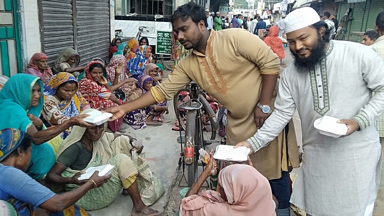 মসজিদের সামনে জড়ো হওয়া ভিক্ষুক, সাহায্যপ্রার্থীর হাতে খাবারের প্যাকেট তুলে দিচ্ছেন বেলাল ও ফুয়াদ। ছবি : কালবেলা
