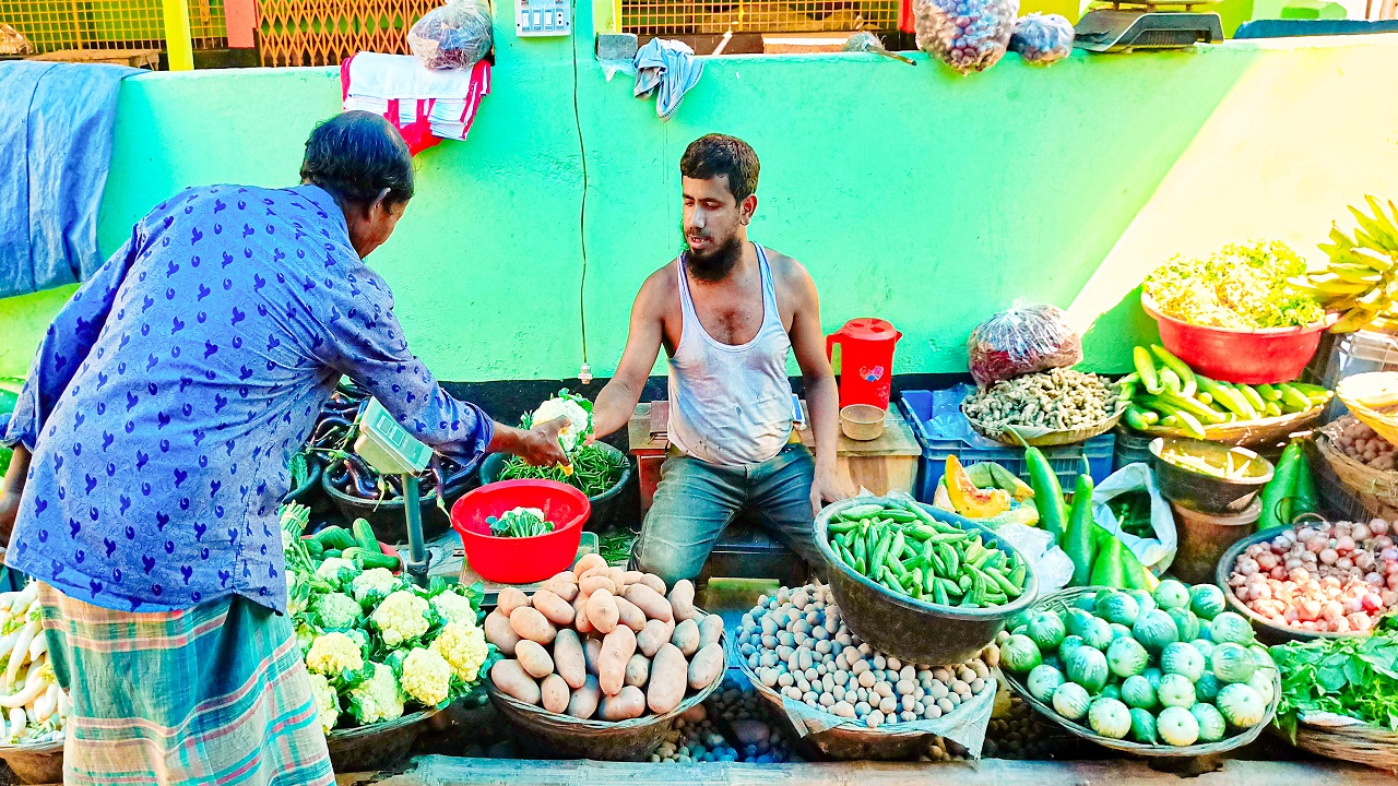 কাঁচা বাজার ঘুরে বিভিন্ন সবজি কিনছেন ক্রেতারা। ছবিটি দিনাজপুরের খানসামা সবজি বাজার থেকে তোলা