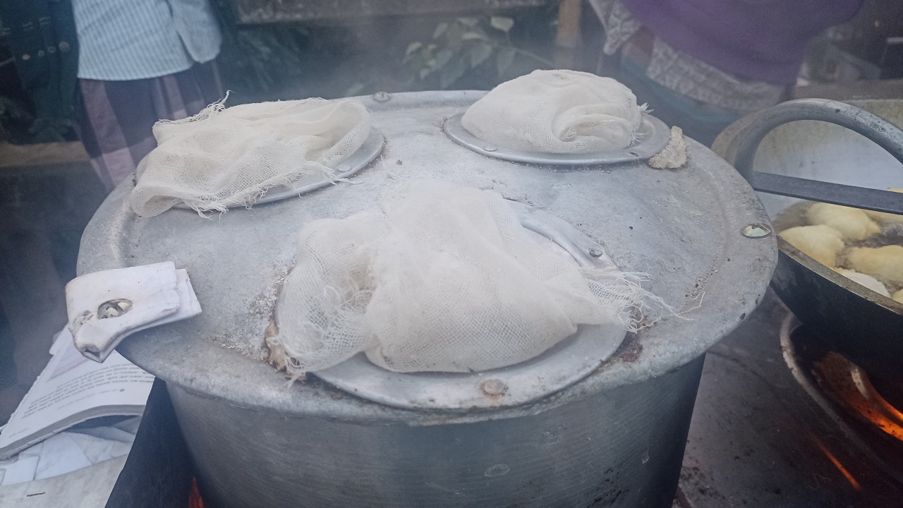 ব্রাহ্মণপাড়ায় পালিতে গরম পানি জ্বালিয়ে তৈরি হচ্ছে ভাঁপা পিঠা। ছবি : কালবেলা