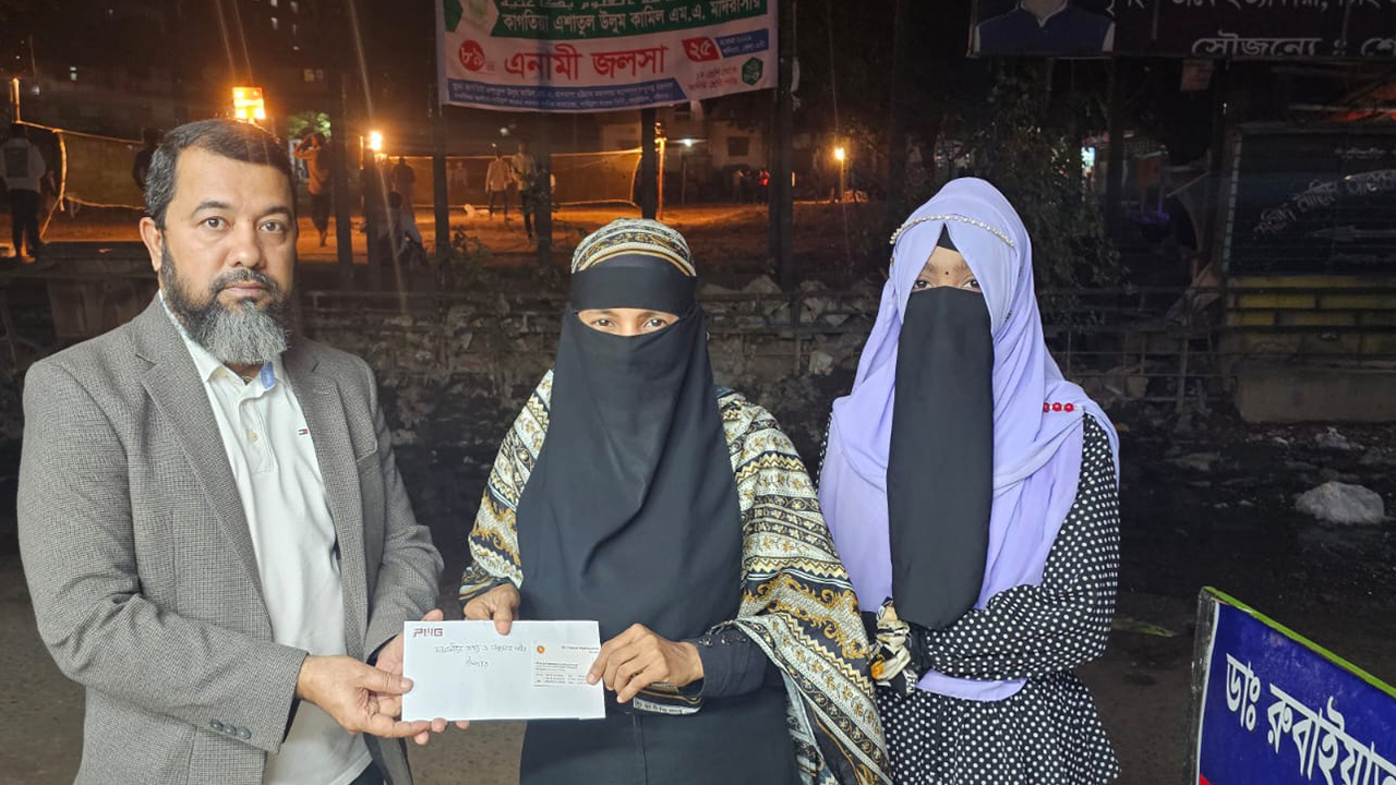 নাজমা আক্তারকে নগদ সহায়তার চেক তুলে দিচ্ছেন তথ্যমন্ত্রীর ব্যক্তিগত কর্মকর্তা এমরুল করিম রাশেদ। ছবি : কালবেলা