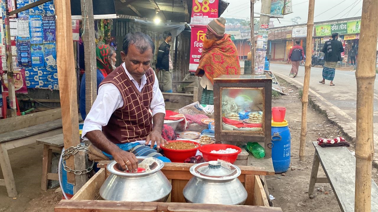 জাজিরার কাজিরহাট বাসস্ট্যান্ডে মহাসড়কের পাশে ভাপা পিঠা বিক্রি করছেন আবুল হোসেন। ছবি : কালবেলা