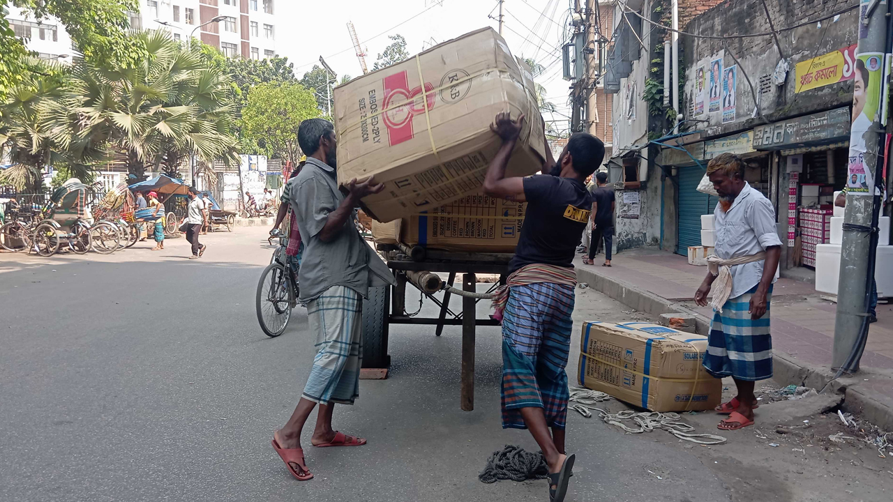 ঠেলাগাড়িতে মালামাল তুলছেন শ্রমিকরা। ছবি : কালবেলা