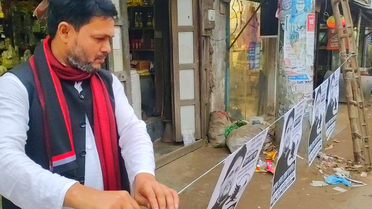 পোস্টার টানাচ্ছেন প্রার্থী গোলাম মোস্তফা হাওলাদার। ছবি : কালবেলা