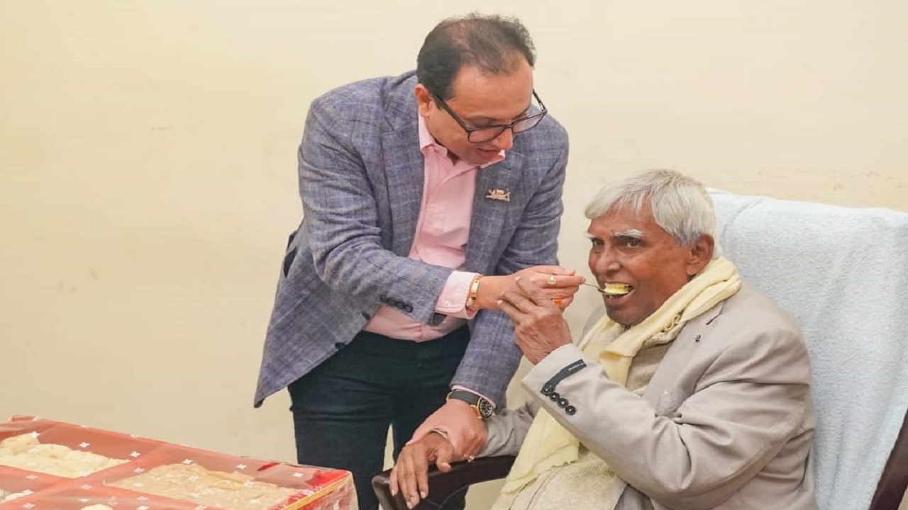 সোলায়মান হক জোয়ার্দ্দার সেলুনকে ফুল দিয়ে শুভেচ্ছা জানিয়ে মিষ্টি মুখ করান দিলীপ কুমার আগরওয়ালা। ছবি : কালবেলা