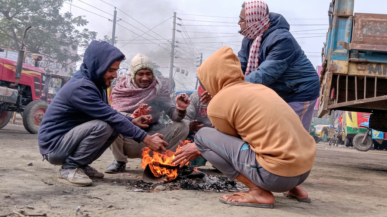 বরগুনায় সড়কের পাশে আগুন জ্বালিয়ে তাপ পোহাচ্ছেন শ্রমজীবীরা। ছবি : কালবেলা
