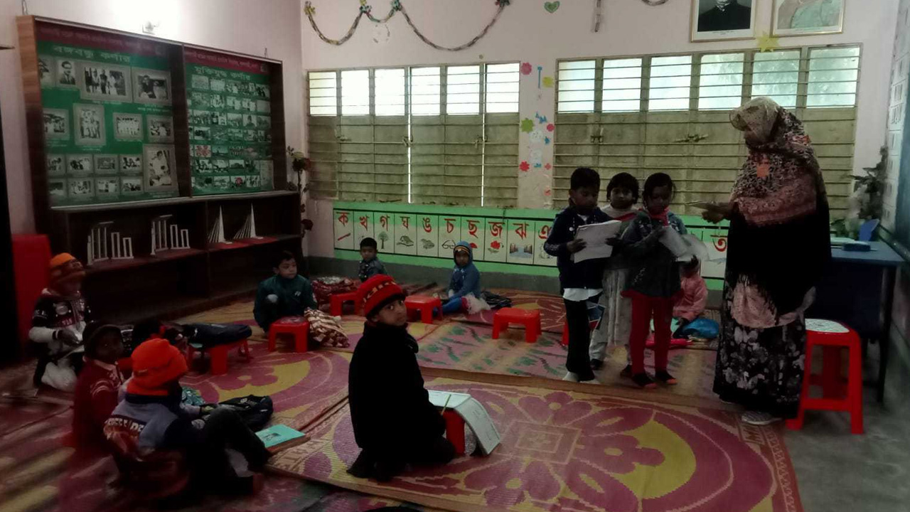বদলগাছী সরকারি প্রাথমিক বিদ্যালয়ের শিশু শিক্ষার্থীদের তীব্র ঠান্ডার মধ্যে মেঝেতে বসিয়ে পাঠদান করা হচ্ছে। ছবি : কালবেলা