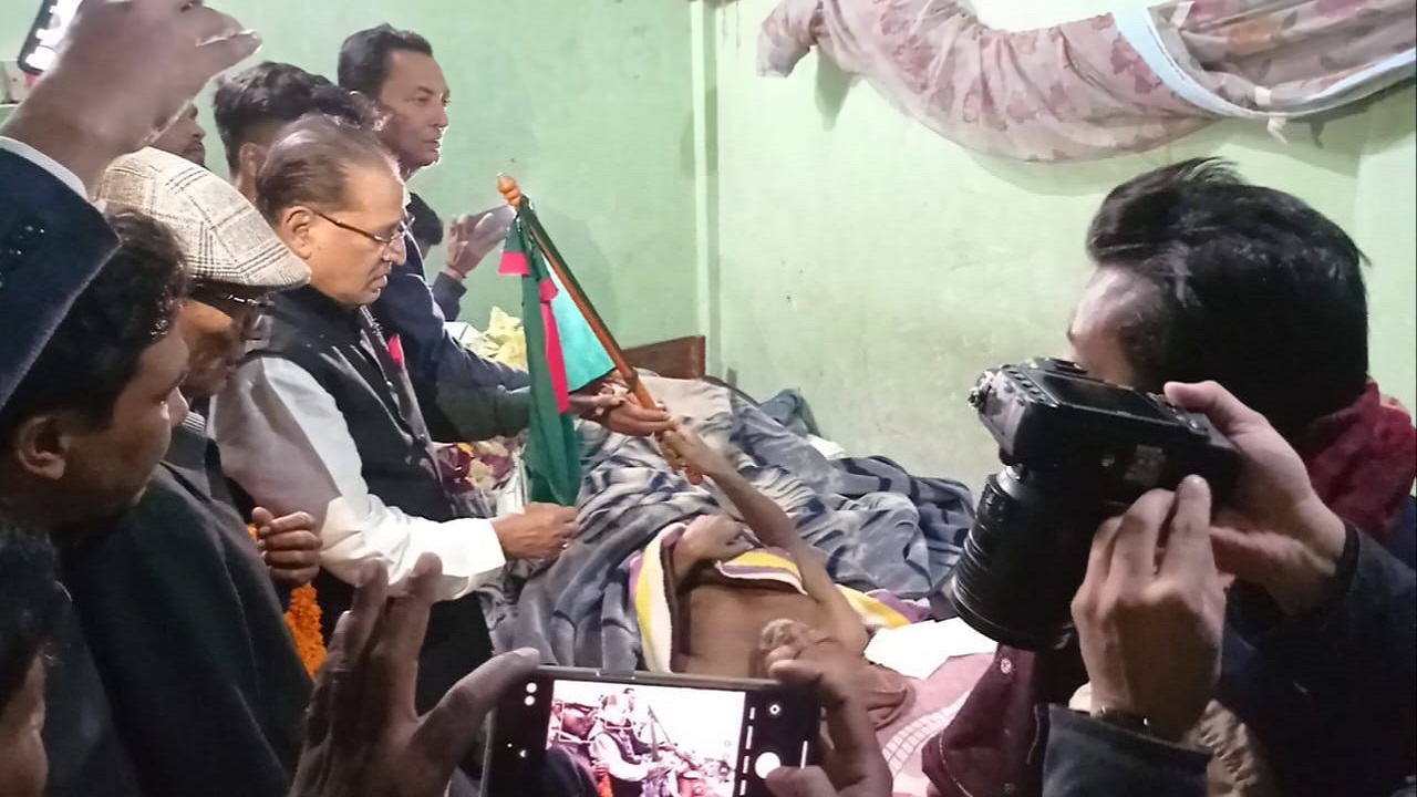 আব্দুর রহমান বিষ্ণুপদের হাতে জাতীয় পতাকা তুলে দিচ্ছেন। ছবি : কালবেলা