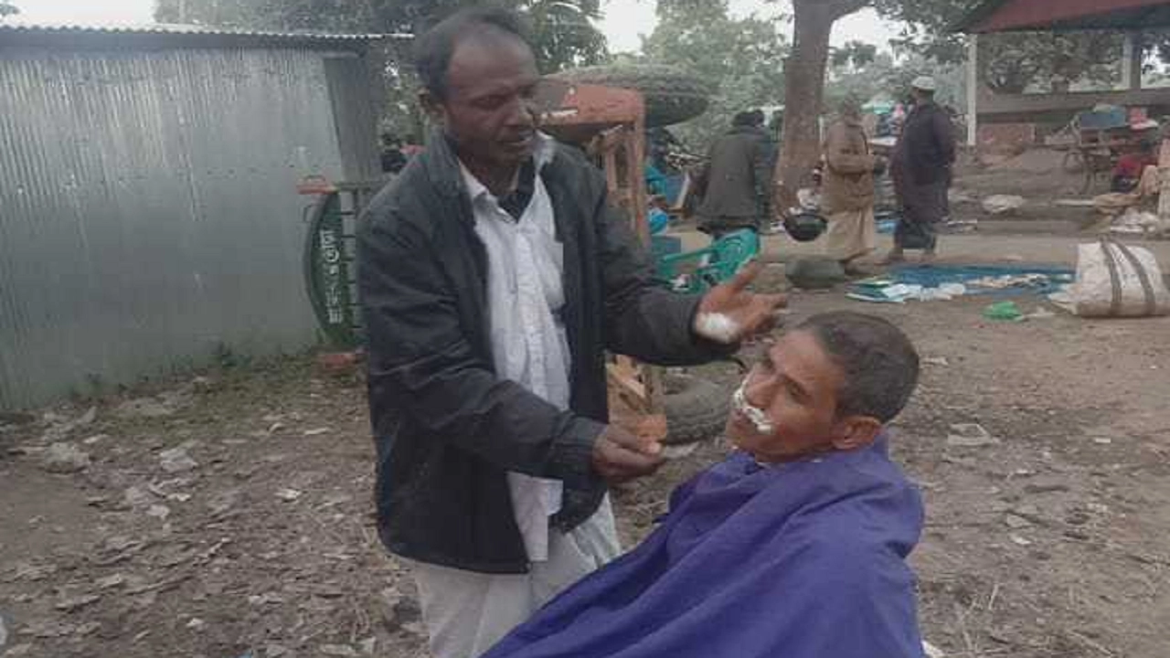 বাজারের পাশে খোলা জায়গায় নরসুন্দরের কাজ করছেন বাবুল সরকার। ছবি : কালবেলা