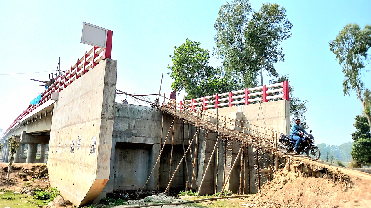 নওগাঁর মান্দায় জোতবাজার খেয়া ঘাটে আত্রাই নদীর ওপর নির্মিত সেতুতে বাঁশের সাঁকো ব্যবহার করে উঠতে হয়। ছবি : কালবেলা