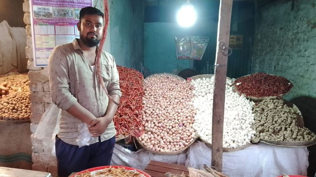 পেঁয়াজ-রসুনের দোকানে ক্রেতার অপেক্ষায় বিক্রেতা। ছবি : কালবেলা