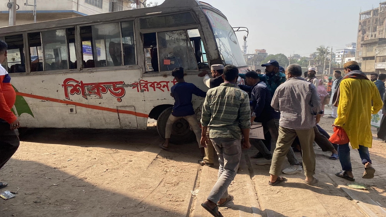 পুলিশ পথচারীদের সহায়তায় শিকড়ের বিকল হওয়া বাসটি অপসারণ করে। ছবি : কালবেলা