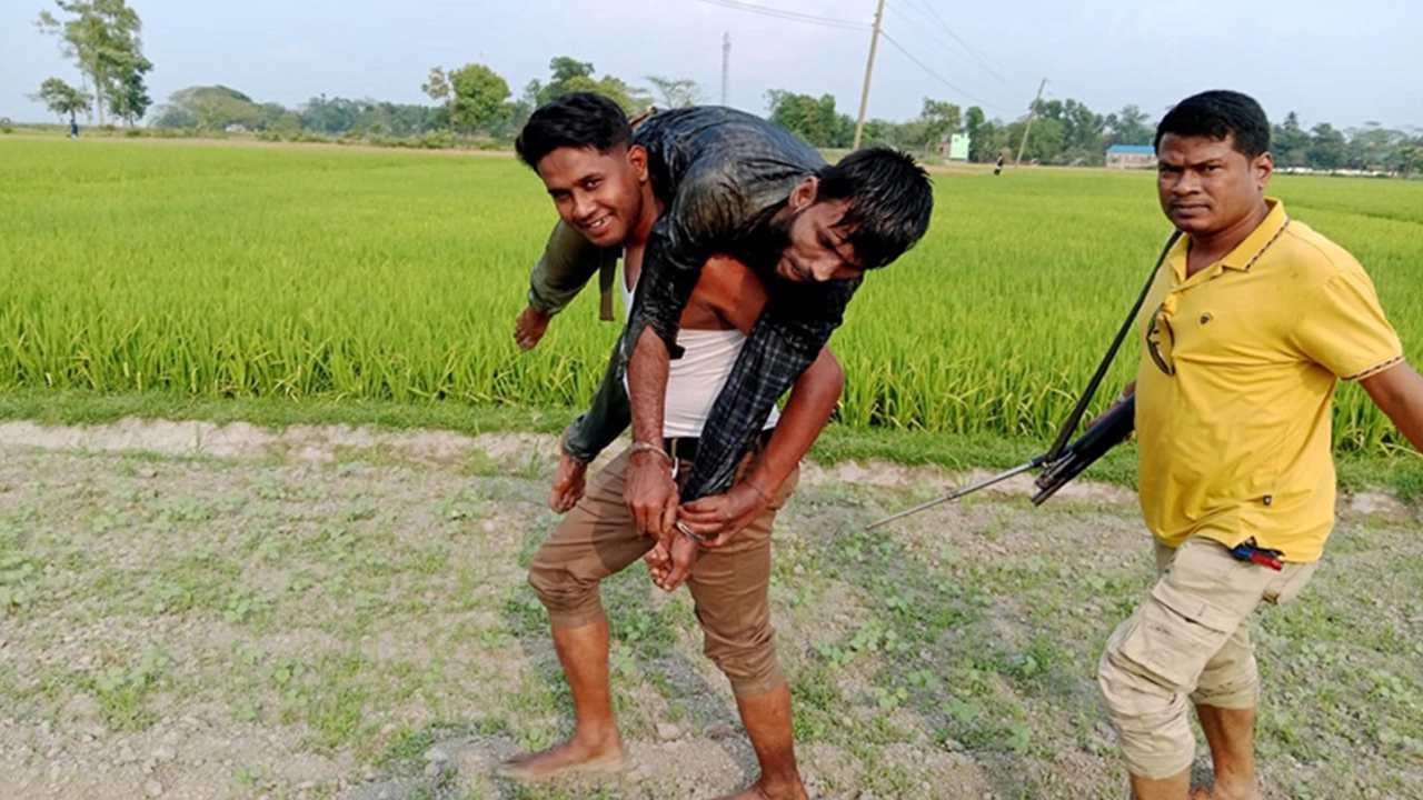 ডাকাতকে পুলিশের কাঁধে তুলে নেওয়ার ছবিটি ভাইরাল হয়। ছবি : সংগৃহীত