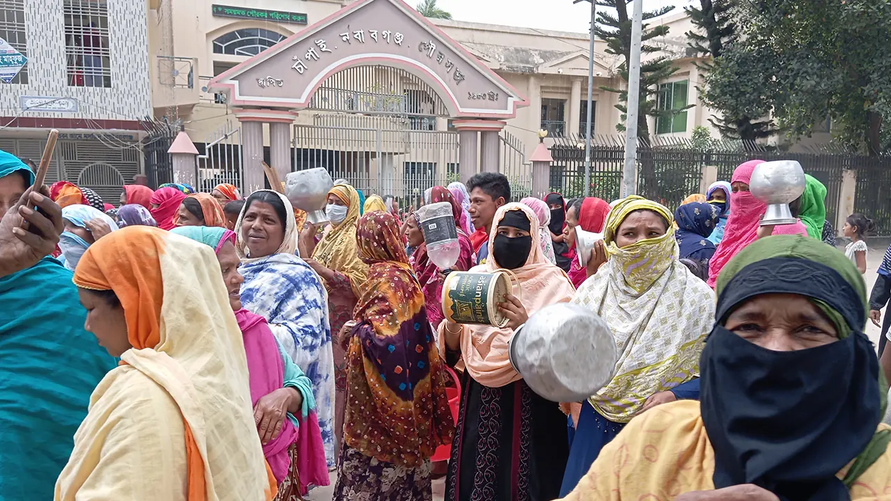 চাঁপাইনবাবগঞ্জ পৌরসভার প্রধান ফটকের সামনে কলস নিয়ে বিক্ষোভ করছেন। ছবি : কালবেলা