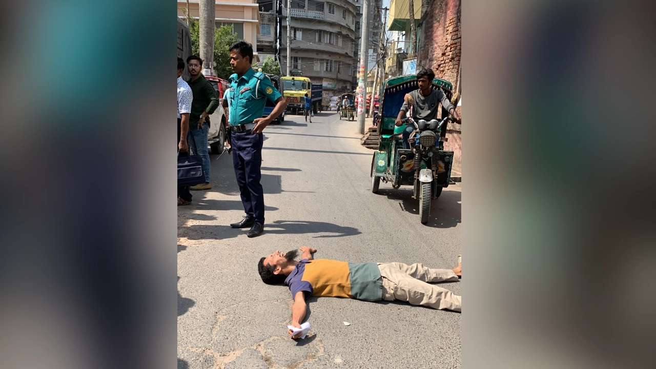 হলে প্রবেশ করতে না পেরে পরীক্ষা কেন্দ্রের সামনের রাস্তায় শুয়ে পড়েন বিসিএস পরীক্ষার্থী ফাহাদ ফয়সাল। ছবি : সংগৃহীত