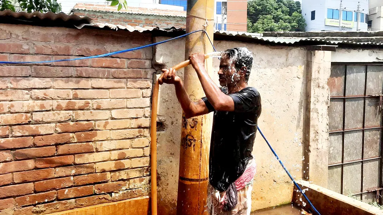 খরতাপে টিউবওয়েলে পানি না পেয়ে সাবমার্সিবলের পানিতে গোসল করছেন ঈশ্বরদীর এক যুবক। ছবি : কালবেলা