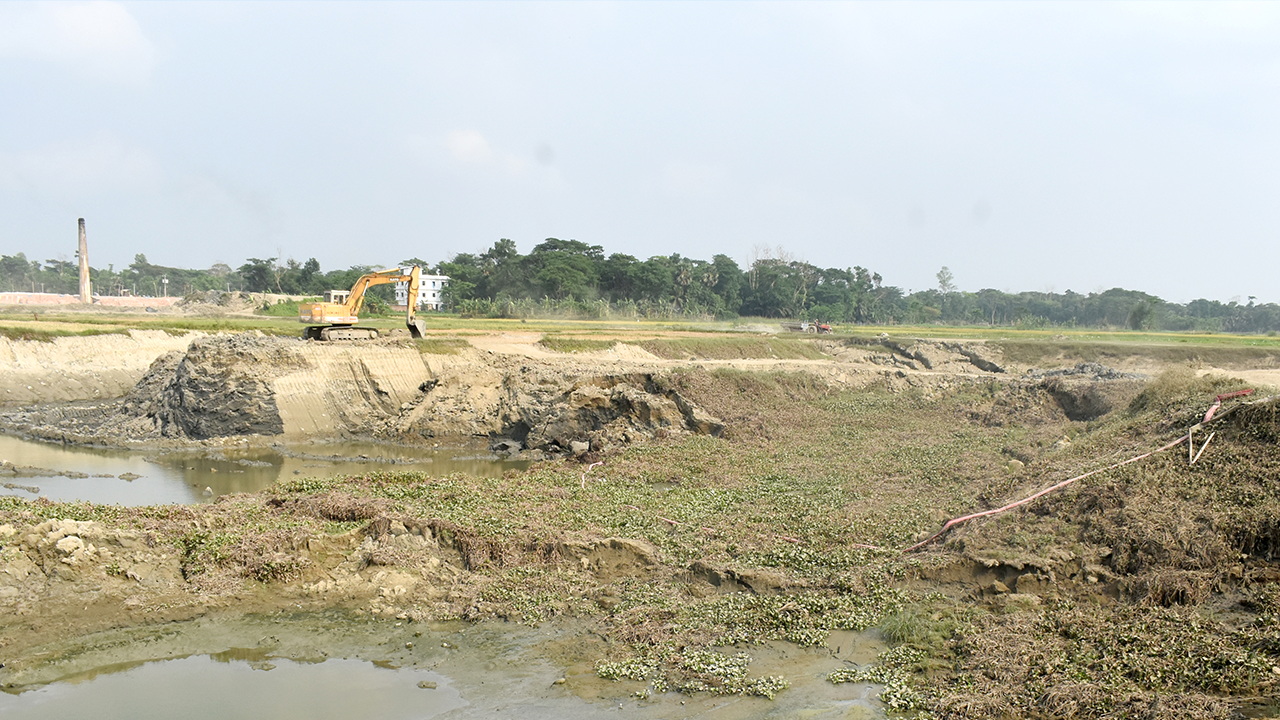 ভেকু মেশিন দিয়ে অবাধে চলছে ফসলি জমির মাটি কাটা। ছবি : কালবেলা