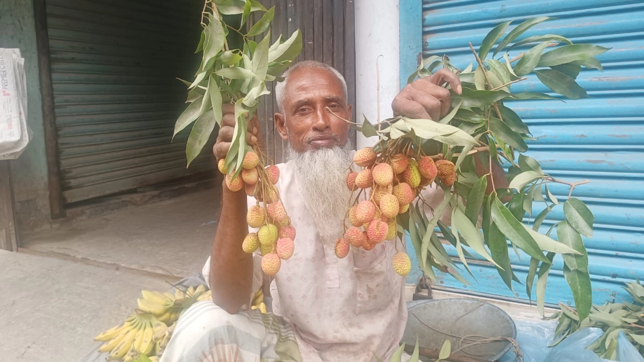 রাজশাহীতে ফুটপাতে লিচু বিক্রি করছেন এক বিক্রেতা। ছবি : কালবেলা