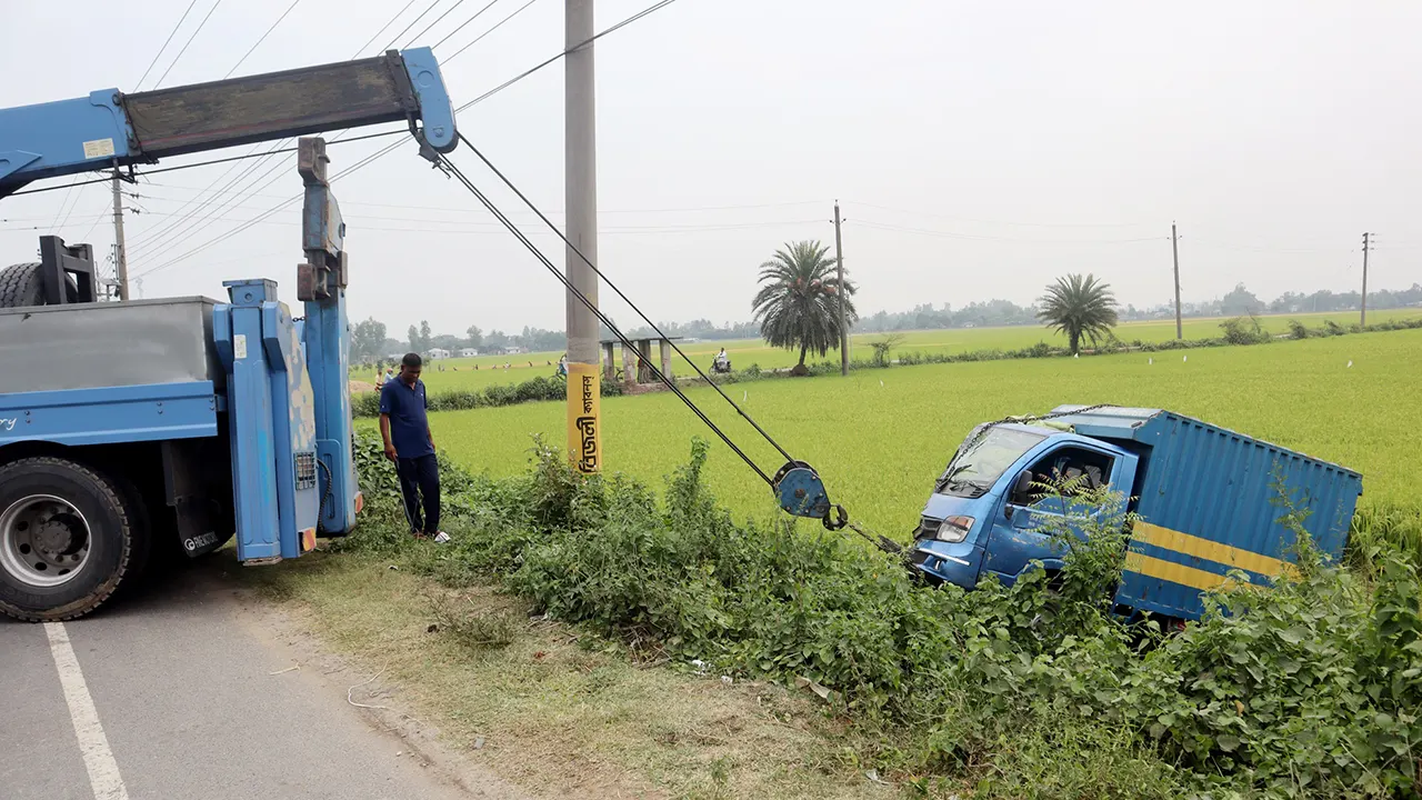 রাস্তার পাশে জমিতে ছিটকে পড়ে যাওয়া পিকআপটি টেনে তোলা হচ্ছে। ছবি : কালবেলা