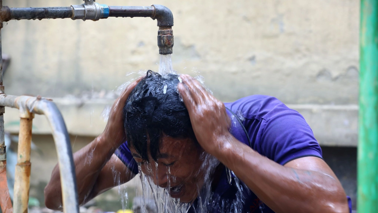 ঢাকার মতিঝিল এলাকায় একটি পানির কল থেকে মাথায় পানি দিচ্ছেন একজন শ্রমিক। পুরোনো ছবি