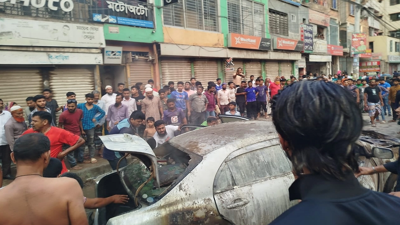 মিরপুর ২ নম্বরের ৬০ ফিট রাস্তায় প্রাইভেটকারটির আগুন নিয়ন্ত্রণে কাজ করেন স্থানীয়রা। ছবি : কালবেলা