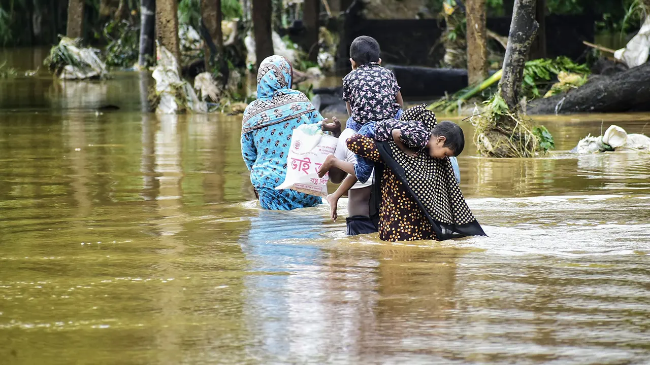 ঘরবাড়ি ও মালামাল ছেড়ে জীবন বাঁচাতে সন্তানদের কাঁধে নিয়ে নিরাপদ আশ্রয়ে ছুটছেন মা-বাবা। ছবি : কালবেলা