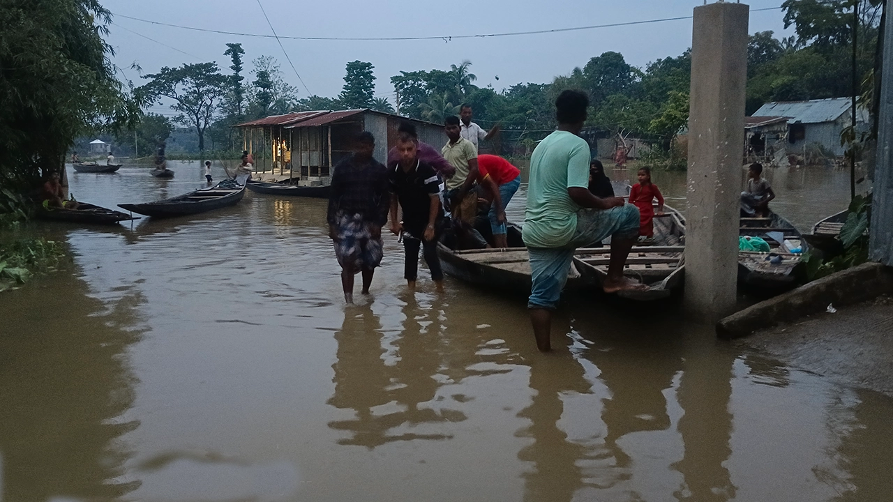 বন্যায় রাস্তা ভেসে যাওয়ায় নৌকা দিয়ে যাতায়াত। ছবি : কালবেলা
