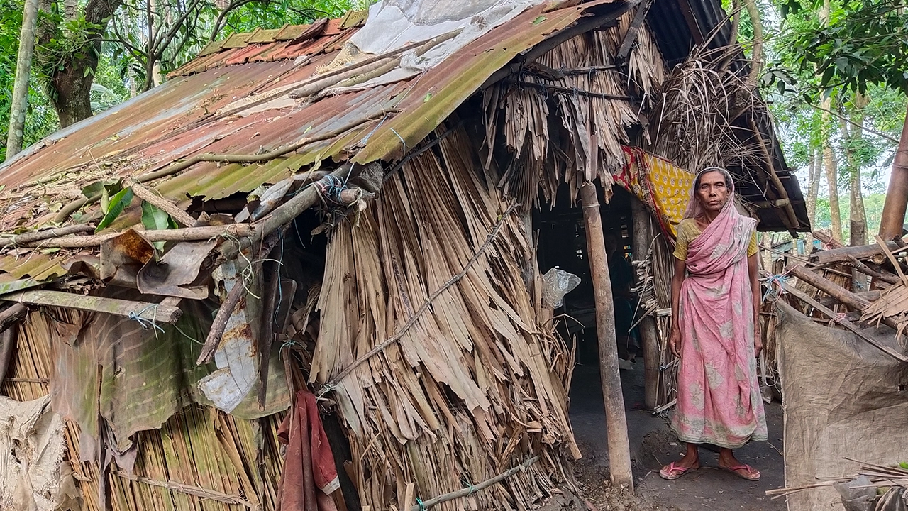 নিজের জরাজীর্ণ ঘরের সামনে হালিমা বেগম। ছবি : কালবেলা