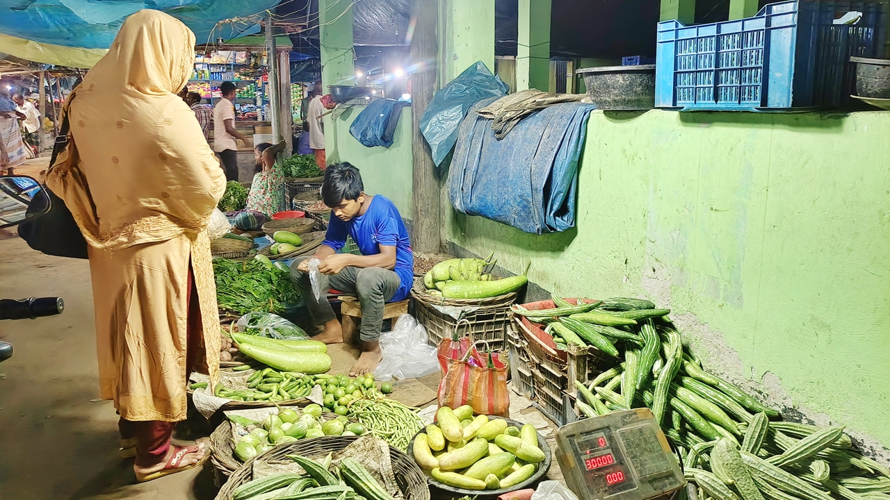 দিনাজপুরের খানসামা বাজারে সবজি কিনছেন এক ক্রেতা। ছবি : কালবেলা