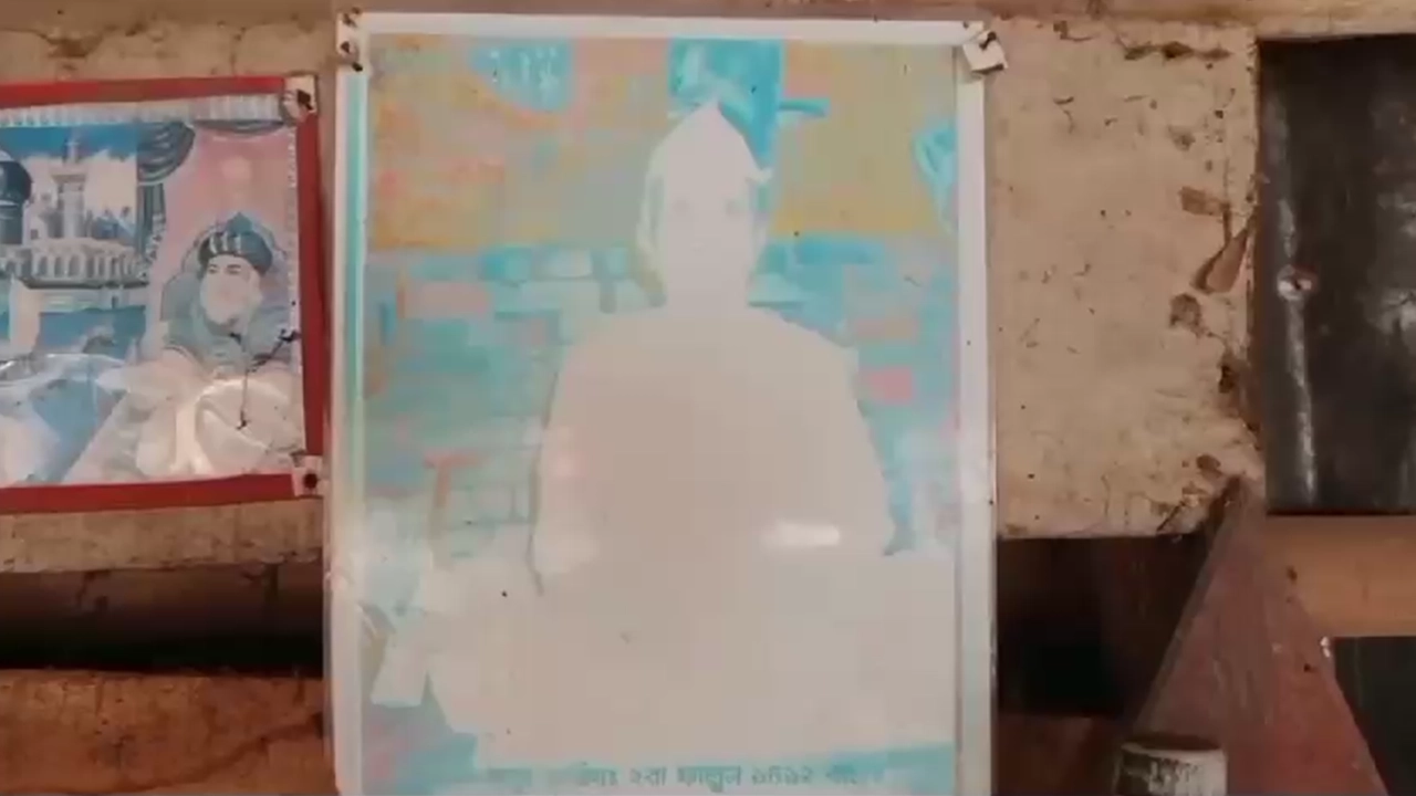 ঘরের দেয়ালে টানানো পীরবাবা খ্যাত শাহজাহান আলী ফকিরের ছবি। ছবি : সংগৃহীত
