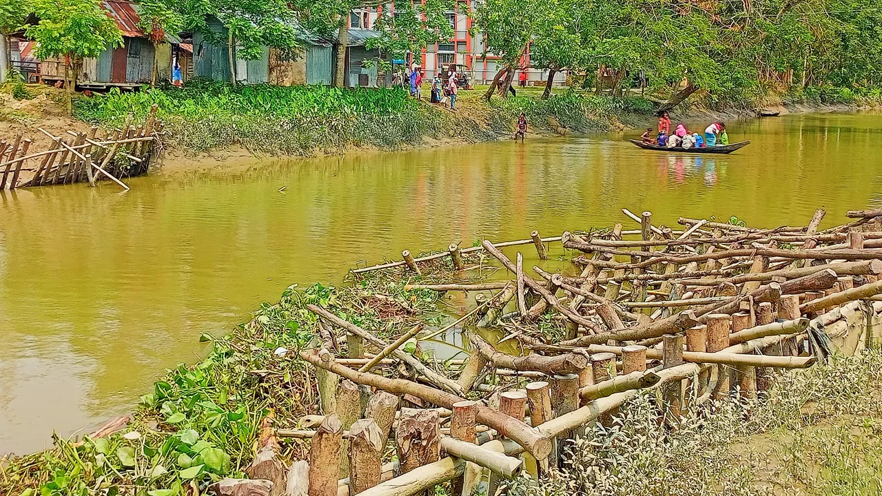 ব্রিজ নির্মাণ না হওয়ায় নৌকা দিয়ে পারাপার হচ্ছেন স্থানীয়রা। ছবি : কালবেলা