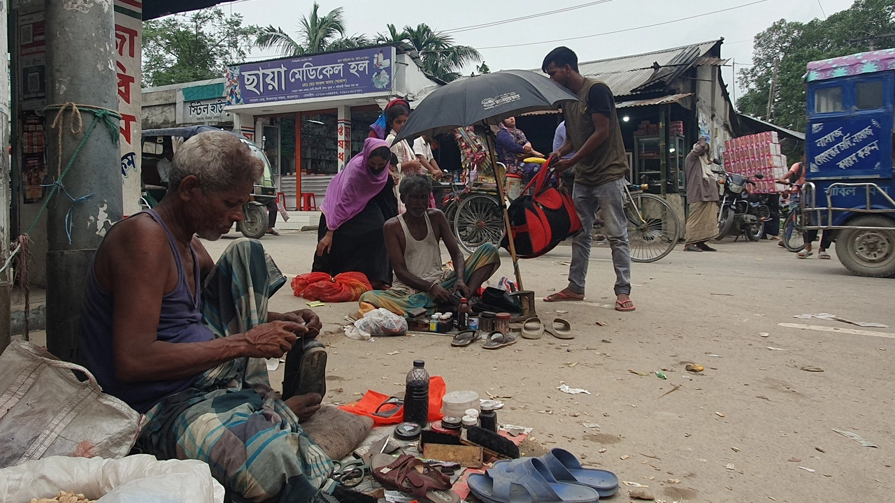 ইসলামপুর বাজারে কাজ করছেন মুচি সম্প্রদায়ের কয়েকজন মানুষ। ছবি : কালবেলা