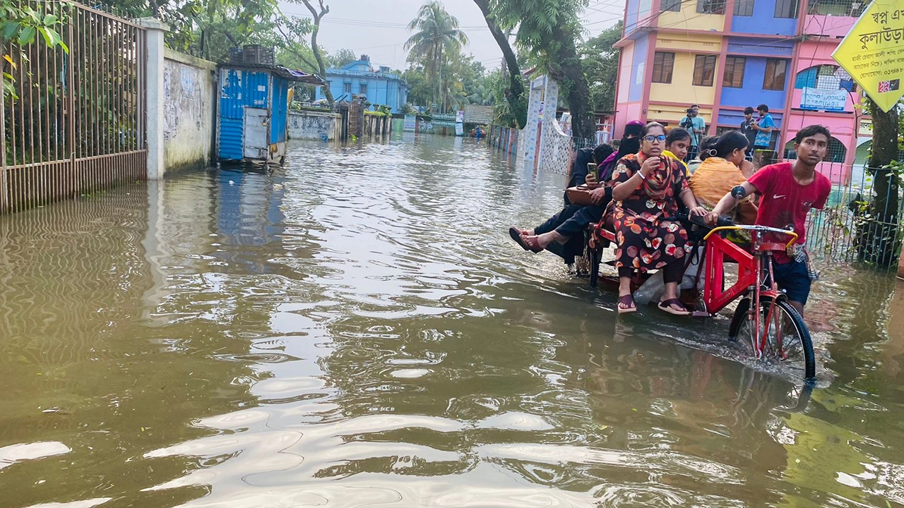 কুলাউড়া উপজেলা পরিষদ এলাকার রাস্তা ডুবে যাওয়ায় রিকশা-ভ্যান দিয়ে চলাচল করছেন লোকজন।  ছবি : কালবেলা