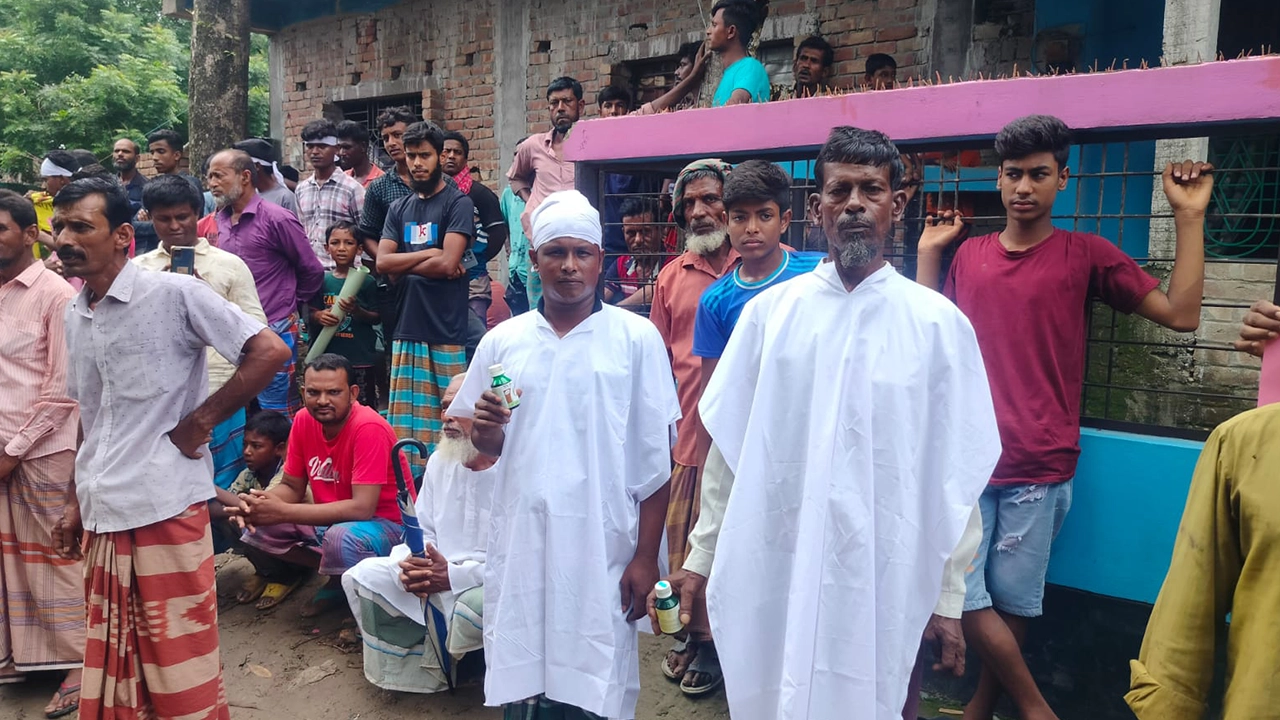 কাফনের কাপড় পরে বিষের বোতল হাতে নিয়ে বিক্ষোভ করেন কৃষকরা। ছবি : কালবেলা