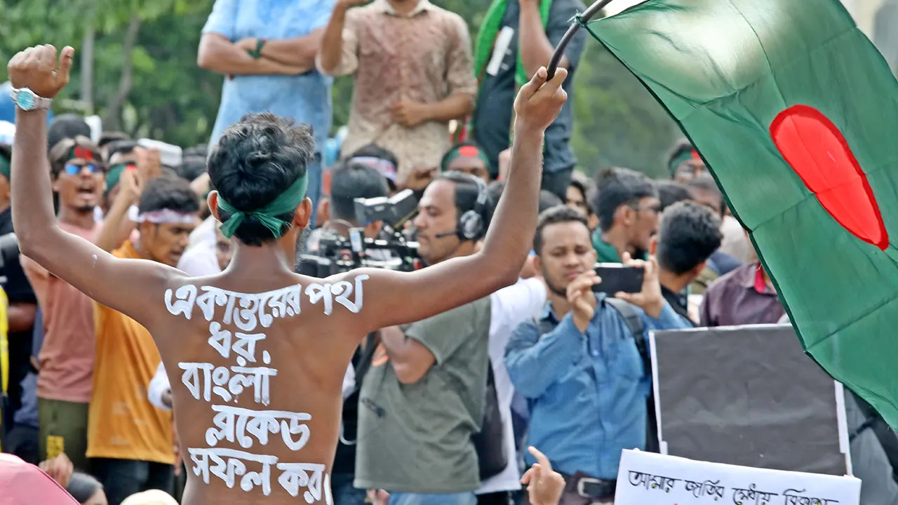 শরীরে স্লোগান লিখে প্রতিবাদ জানাচ্ছেন এক শিক্ষার্থী। ছবি : কালবেলা